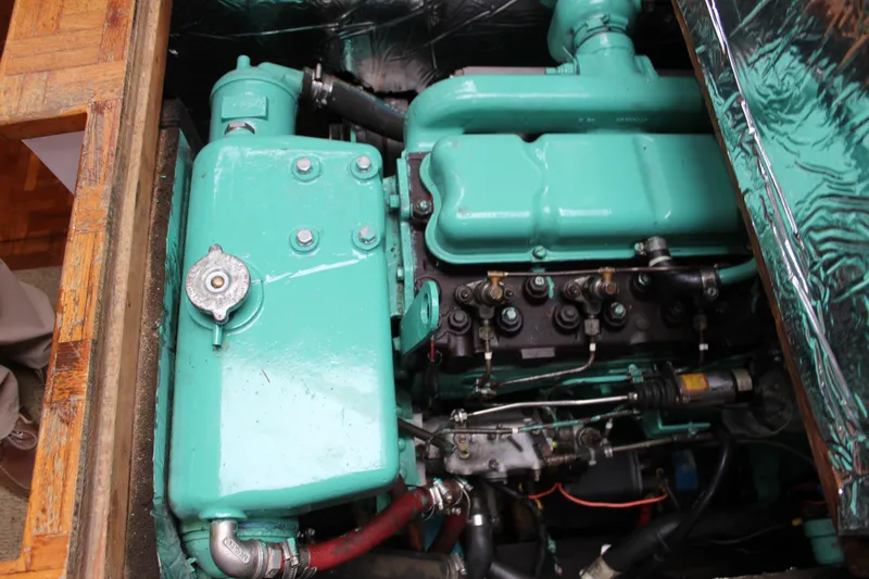 Slide: The Image of Engine compartment of a 1975 William Garden Porpoise boat, featuring a teal engine. - 55