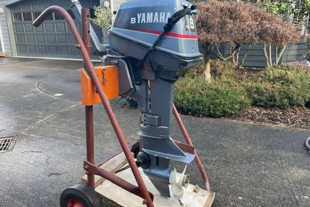 Slide: The Image of 1975 William Garden Porpoise with Yamaha outboard motor on a wheeled stand. - 59