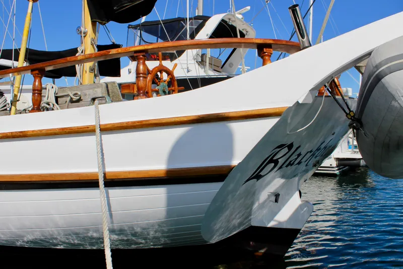 Slide: The Image of Classic 1975 William Garden Porpoise sailboat docked, featuring wooden accents and elegant design. - 6