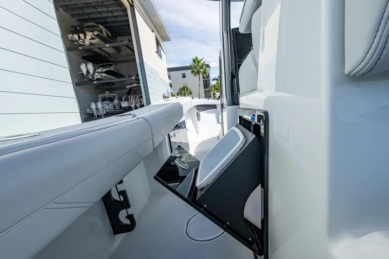 Slide: The Image of 2026 Yellowfin 36 Offshore boat interior with storage compartment, docked near a boat storage facility. - 39
