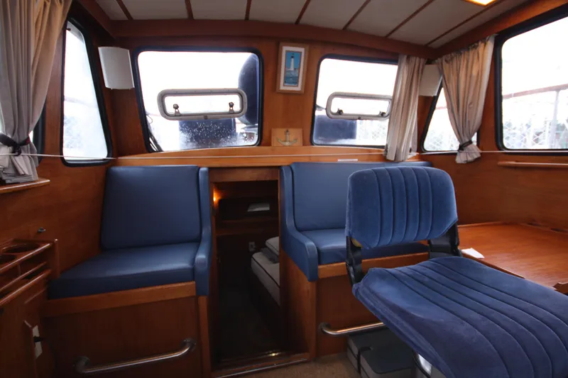 Slide: The Image of Interior of 1984 Nauticat 33 sailboat with blue seating and wooden finishes. - 10