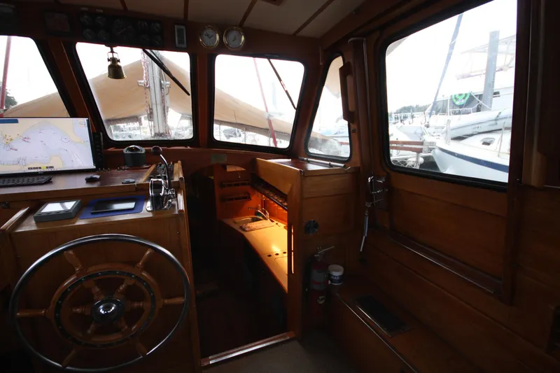 Slide: The Image of Interior of 1984 Nauticat 33 sailboat with wooden helm and navigation equipment. - 12