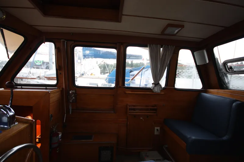 Slide: The Image of Interior of 1984 Nauticat 33 sailboat with wooden paneling and blue seating. - 15