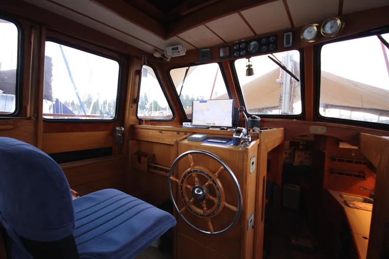 Slide: The Image of Interior of 1984 Nauticat 33 sailboat, featuring wooden helm and navigation equipment. - 16