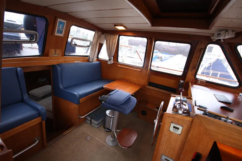 Slide: The Image of Interior of 1984 Nauticat 33 sailboat with blue seating and wooden finishes. - 2