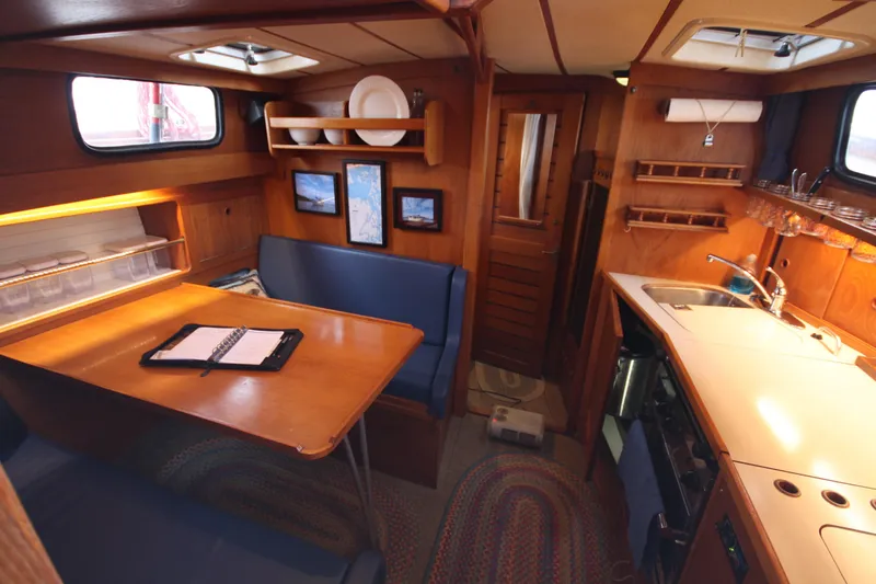 Slide: The Image of Interior of 1984 Nauticat 33 sailboat with cozy dining and kitchen area. - 20