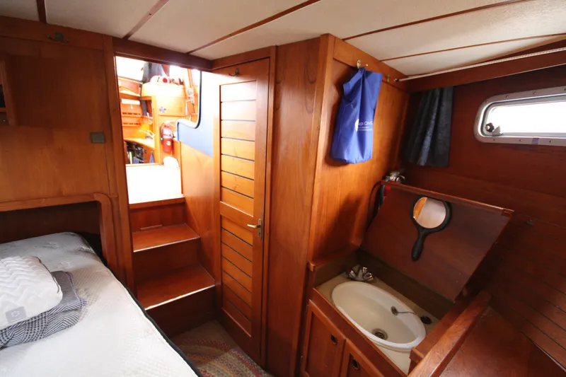 Slide: The Image of Cozy 1984 Nauticat 33 cabin interior with wooden finish, bed, and compact sink area. - 30
