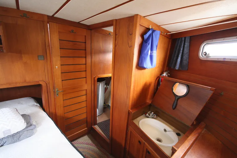 Slide: The Image of Cozy 1984 Nauticat 33 yacht cabin with wooden interior and compact sink. - 33