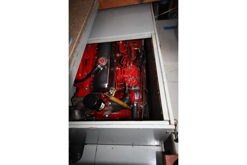 Slide: The Image of Engine compartment of a 1984 Nauticat 33 sailboat, showcasing a red marine engine. - 37
