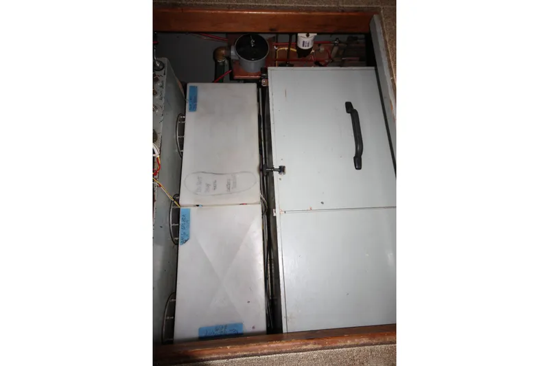 Slide: The Image of Engine compartment of a 1984 Nauticat 33 sailboat, featuring storage and mechanical components. - 39