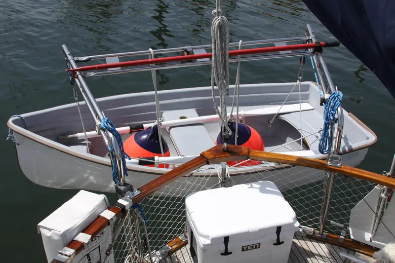 Slide: The Image of Nauticat 33 sailboat with dinghy and Yeti cooler, 1984 model, docked on calm water. - 46
