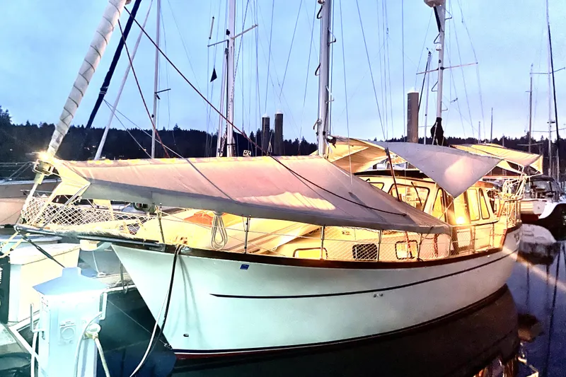 Slide: The Image of 1984 Nauticat 33 sailboat docked at marina during twilight, illuminated by soft lighting. - 49