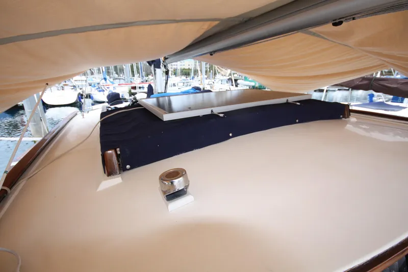 Slide: The Image of 1984 Nauticat 33 sailboat deck under beige canopy in marina setting. - 51
