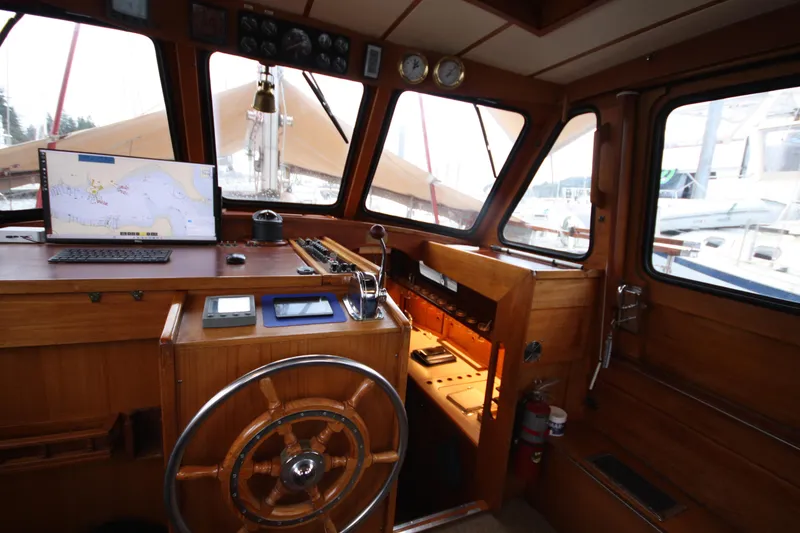 Slide: The Image of Interior of 1984 Nauticat 33 sailboat cockpit with navigation equipment and wooden steering wheel. - 6
