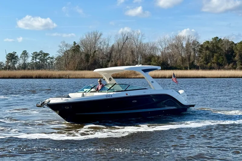 Slide: The Image of 2021 Sea Ray SLX 310 Outboard cruising on a serene river with trees in the background. - 10