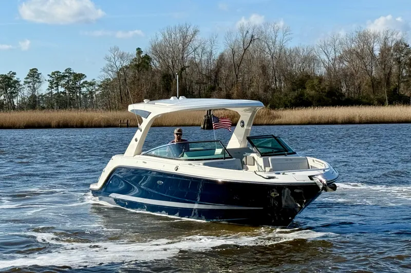 Slide: The Image of 2021 Sea Ray SLX 310 Outboard boat docked, featuring dual engines and spacious seating. - 12