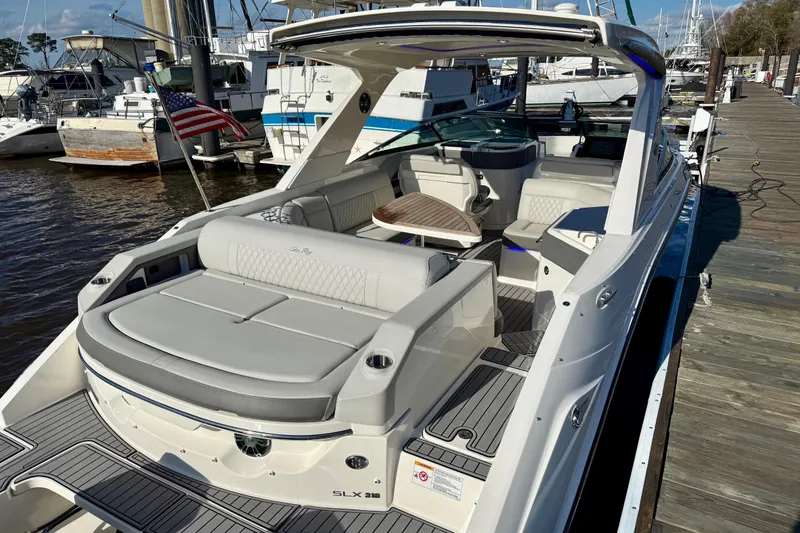 Slide: The Image of Luxurious 2021 Sea Ray SLX 310 Outboard boat interior with elegant seating and wooden table. - 17
