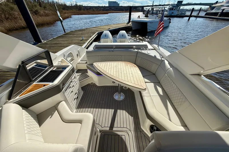 Slide: The Image of Luxurious 2021 Sea Ray SLX 310 Outboard boat interior with elegant seating and table. - 20