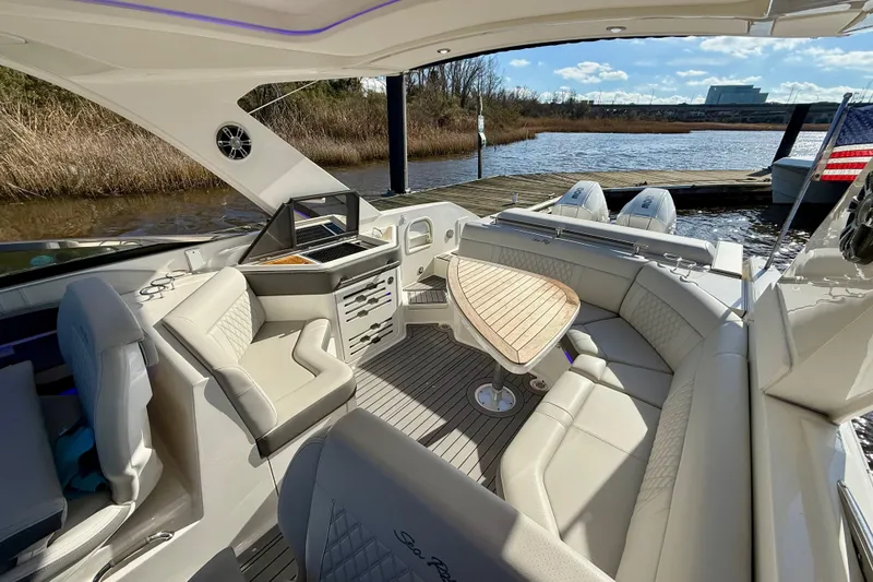 Slide: The Image of 2021 Sea Ray SLX 310 Outboard interior with seating, storage, and sleek design. - 21