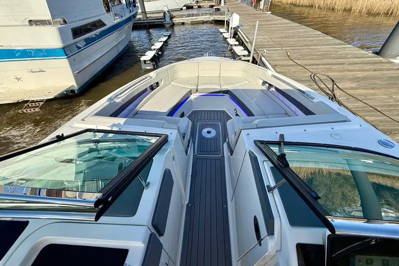 Slide: The Image of 2021 Sea Ray SLX 310 Outboard boat interior with luxurious seating at a marina. - 32