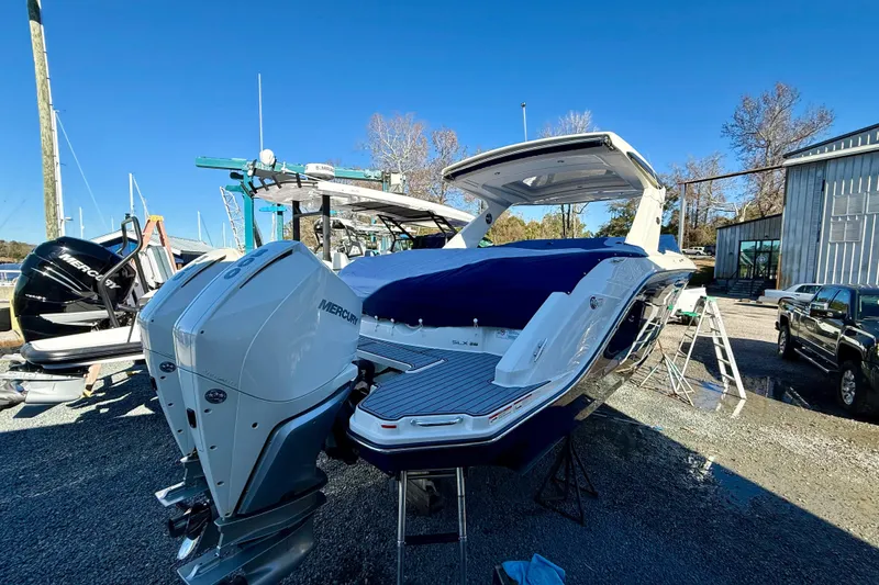 Slide: The Image of 2021 Sea Ray SLX 310 Outboard boat with dual Mercury engines, docked outdoors. - 38