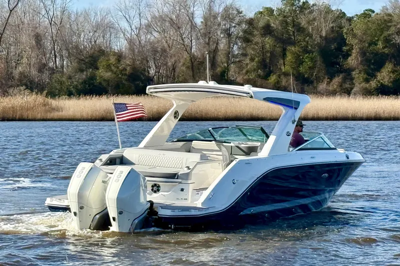 Slide: The Image of 2021 Sea Ray SLX 310 Outboard boat cruising on a river with American flag. - 4