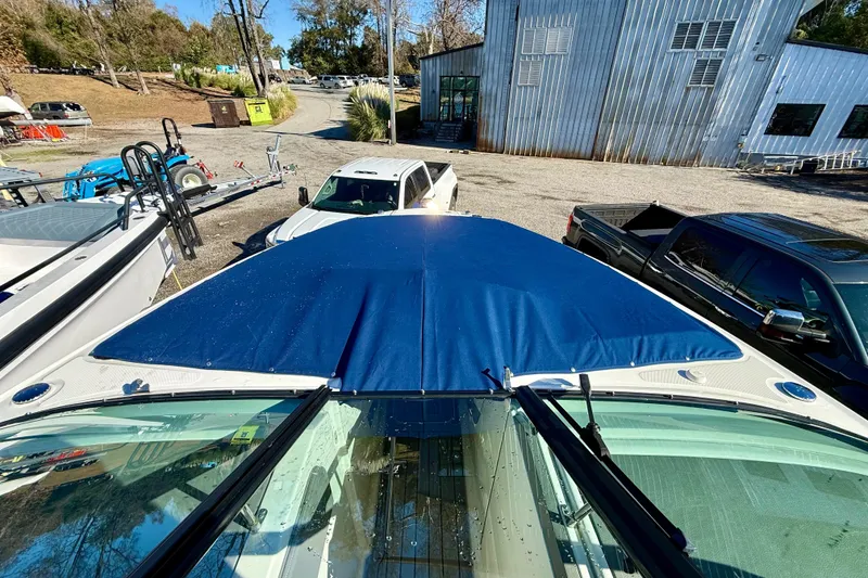 Slide: The Image of 2021 Sea Ray SLX 310 Outboard with blue cover in a parking lot. - 40