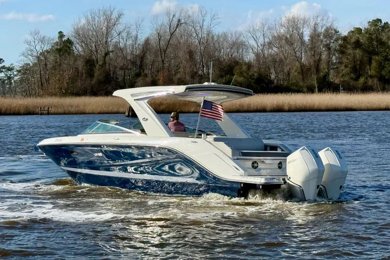 Slide: The Image of 2021 Sea Ray SLX 310 Outboard cruising on a river with American flag. - 7