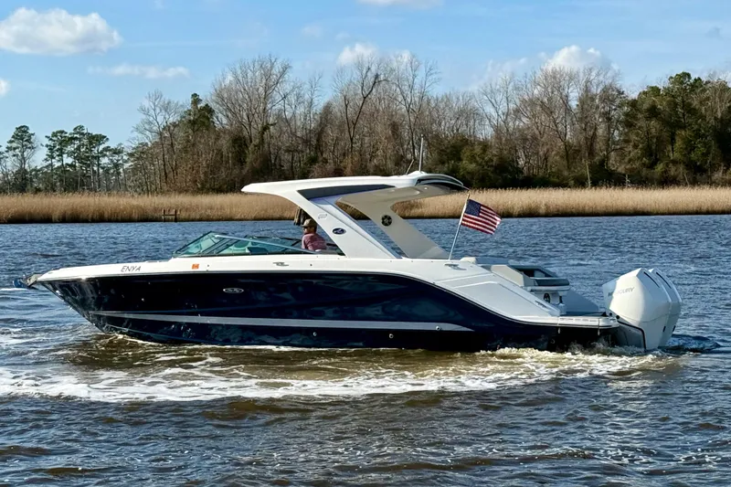 Slide: The Image of 2021 Sea Ray SLX 310 Outboard cruising on a river with American flag. - 8