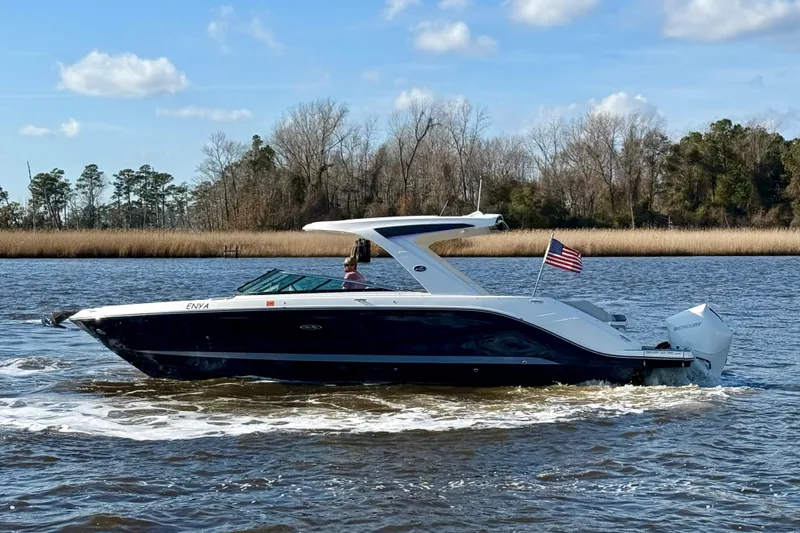 Slide: The Image of 2021 Sea Ray SLX 310 Outboard cruising on a scenic river with trees in the background. - 9