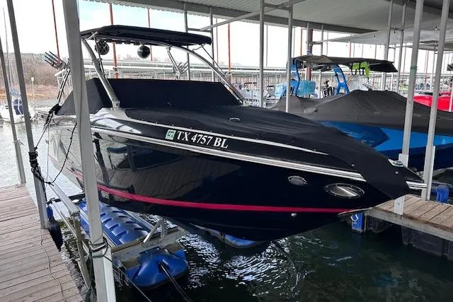 Slide: The Image of 2011 Cobalt 242 WSS boat docked, covered, and elevated on a lift in a marina. - 24