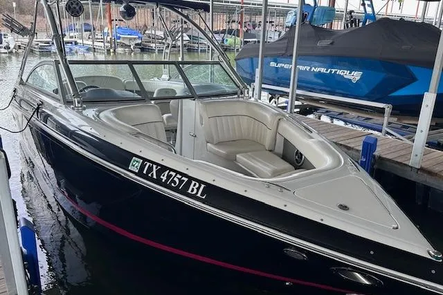 Slide: The Image of 2011 Cobalt 242 WSS boat docked, featuring sleek design and comfortable seating. - 5