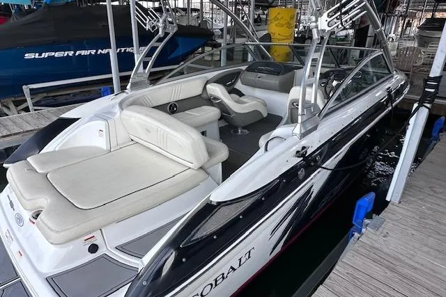 Slide: The Image of 2011 Cobalt 242 WSS boat with sleek design and comfortable seating at a dock. - 6