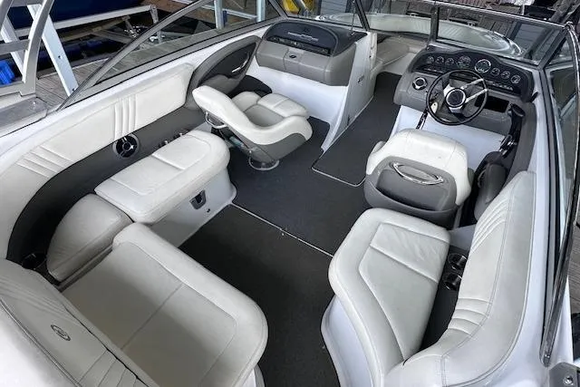 Slide: The Image of 2011 Cobalt 242 WSS boat interior with white leather seating and modern dashboard. - 8