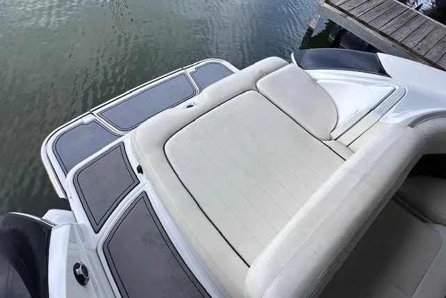 Slide: The Image of 2011 Cobalt 242 WSS boat with white seating and swim platform by the water. - 9