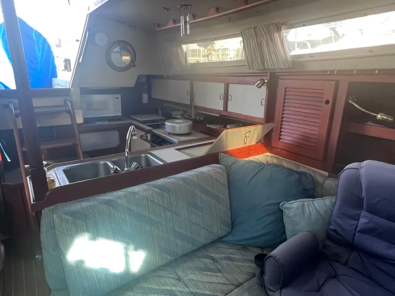 Slide: The Image of Interior of 1989 Catalina 36 sailboat with cozy seating and compact kitchen area. - 11