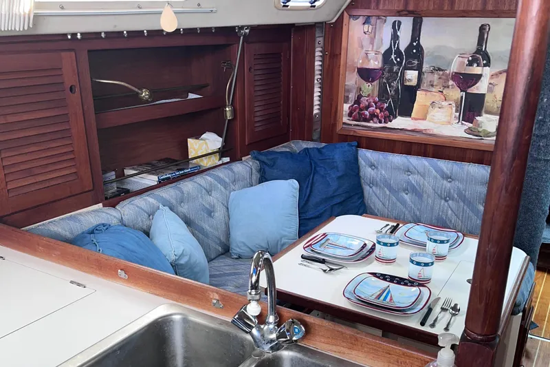 Slide: The Image of Cozy dining area in 1989 Catalina 36 sailboat with blue cushions and nautical decor. - 2