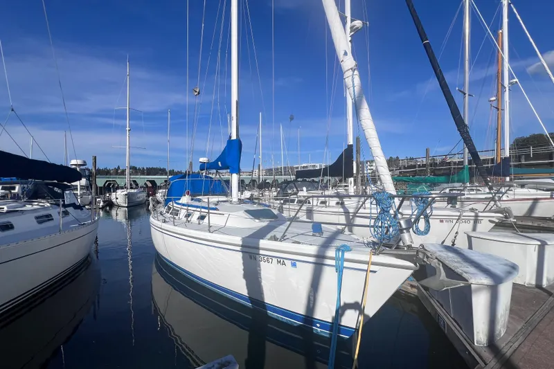 Slide: The Image of 1989 Catalina 36 sailboat docked at a marina under clear blue skies. - 24
