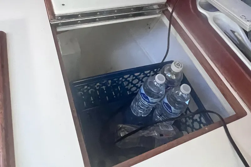 Slide: The Image of Storage compartment in 1989 Catalina 36 yacht with water bottles and cables. - 29