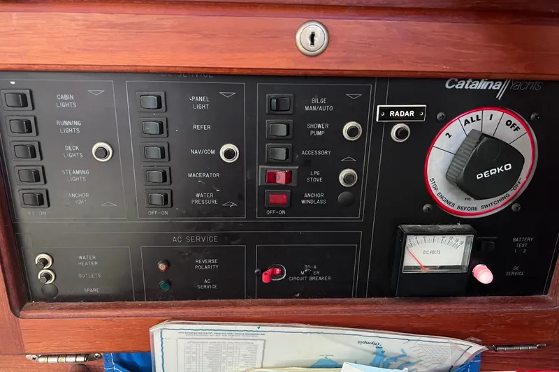 Slide: The Image of Control panel of a 1989 Catalina 36 sailboat with various switches and gauges. - 32