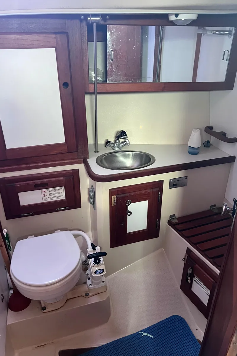 Slide: The Image of 1989 Catalina 36 yacht bathroom with sink, toilet, and wooden cabinetry. - 41