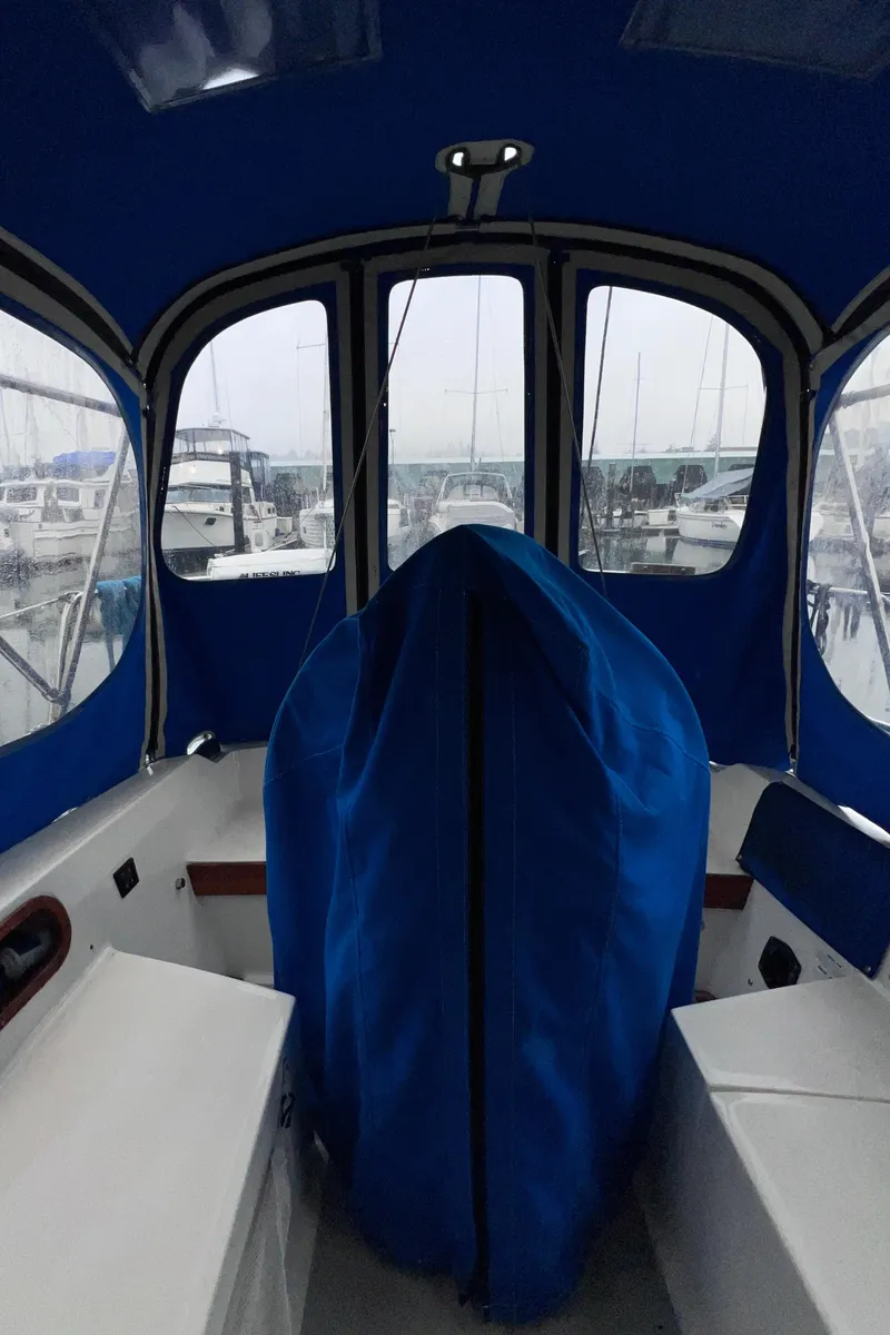 Slide: The Image of 1989 Catalina 36 sailboat cockpit with blue canopy and marina view. - 44