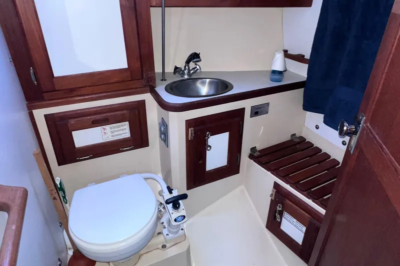 Slide: The Image of 1989 Catalina 36 yacht bathroom with sink, toilet, and wooden cabinetry. - 47