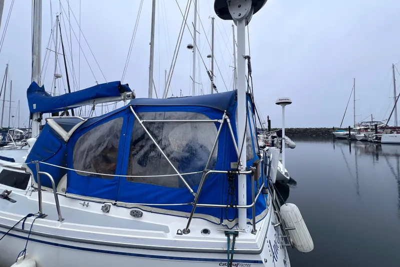Slide: The Image of 1989 Catalina 36 sailboat with blue canopy docked in a marina. - 5