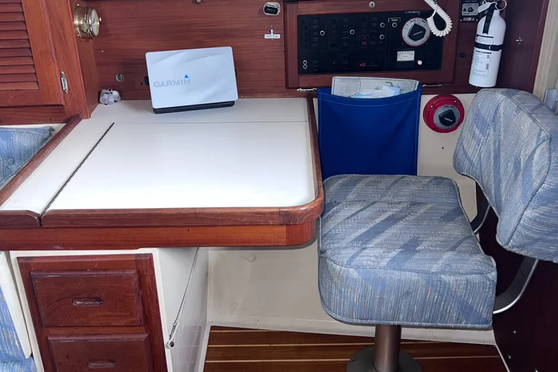 Slide: The Image of Navigation station inside a 1989 Catalina 36 sailboat with chart table and cushioned seat. - 50