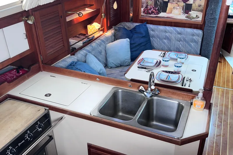 Slide: The Image of Interior of a 1989 Catalina 36 sailboat with a cozy dining area and kitchen. - 7
