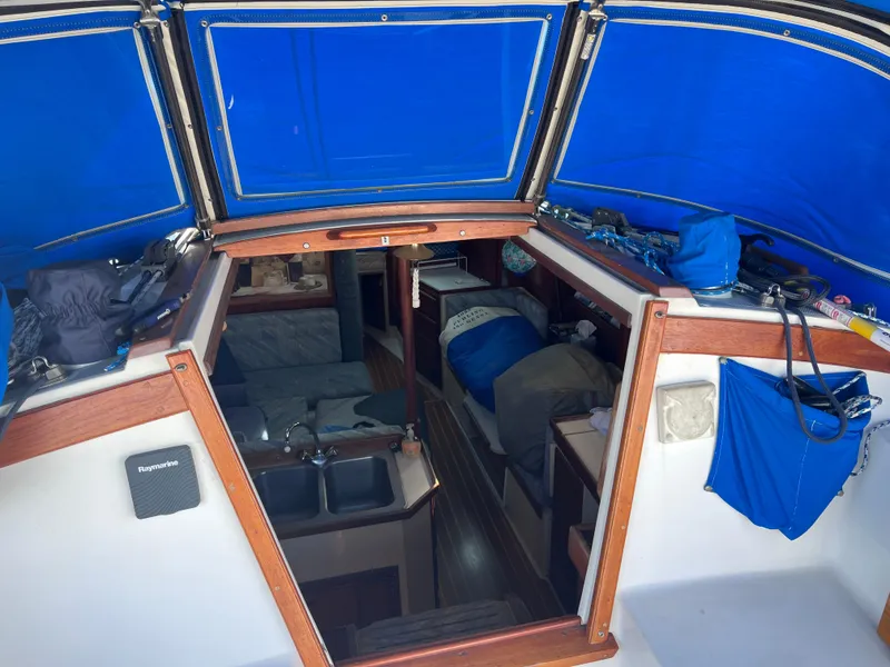 Slide: The Image of Interior view of a 1989 Catalina 36 sailboat with blue canopy and cozy cabin. - 9