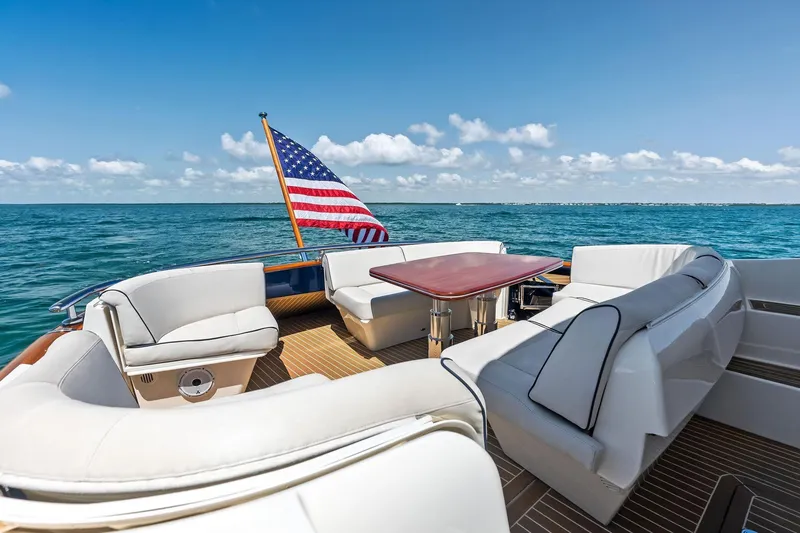 Slide: The Image of Luxurious 2019 Zeelander Z55 yacht deck with seating, table, and American flag on open sea. - 20