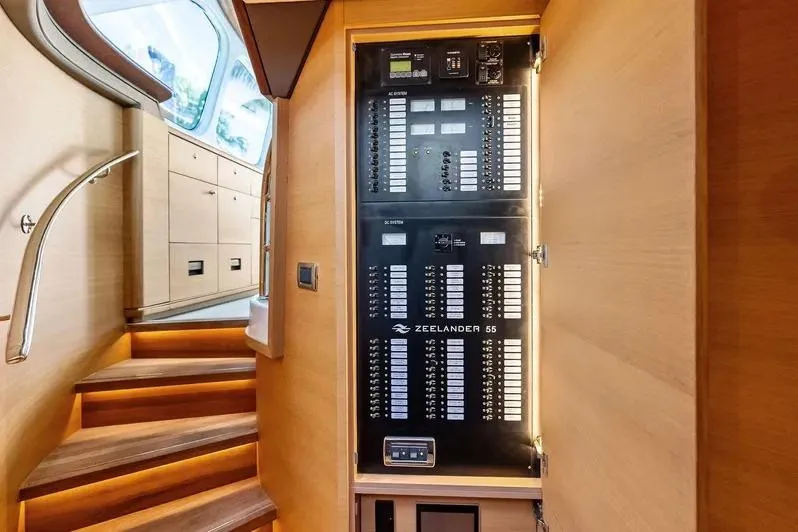Slide: The Image of Electrical panel inside 2019 Zeelander Z55 yacht, featuring wooden interior and staircase. - 39