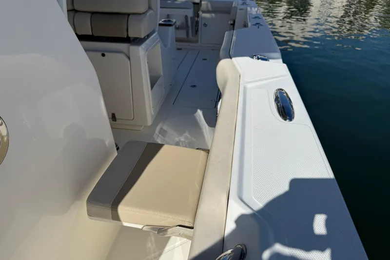 Slide: The Image of 2023 Boston Whaler 360 Outrage boat interior with seating and water view. - 11